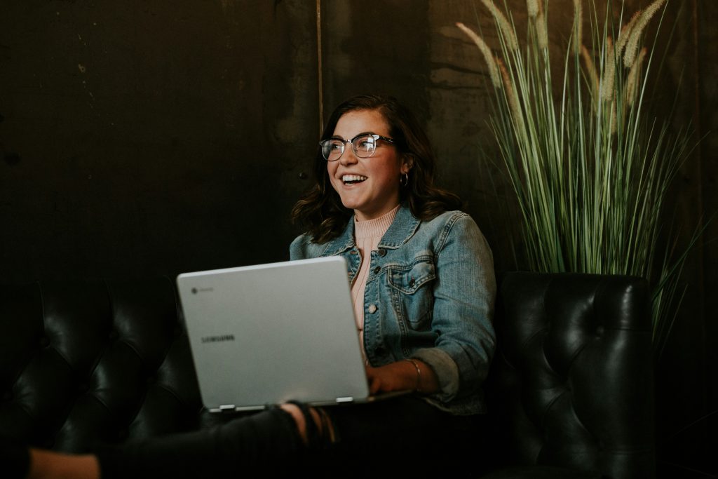 A 9Wickets player smiling while finding her answers on a laptop